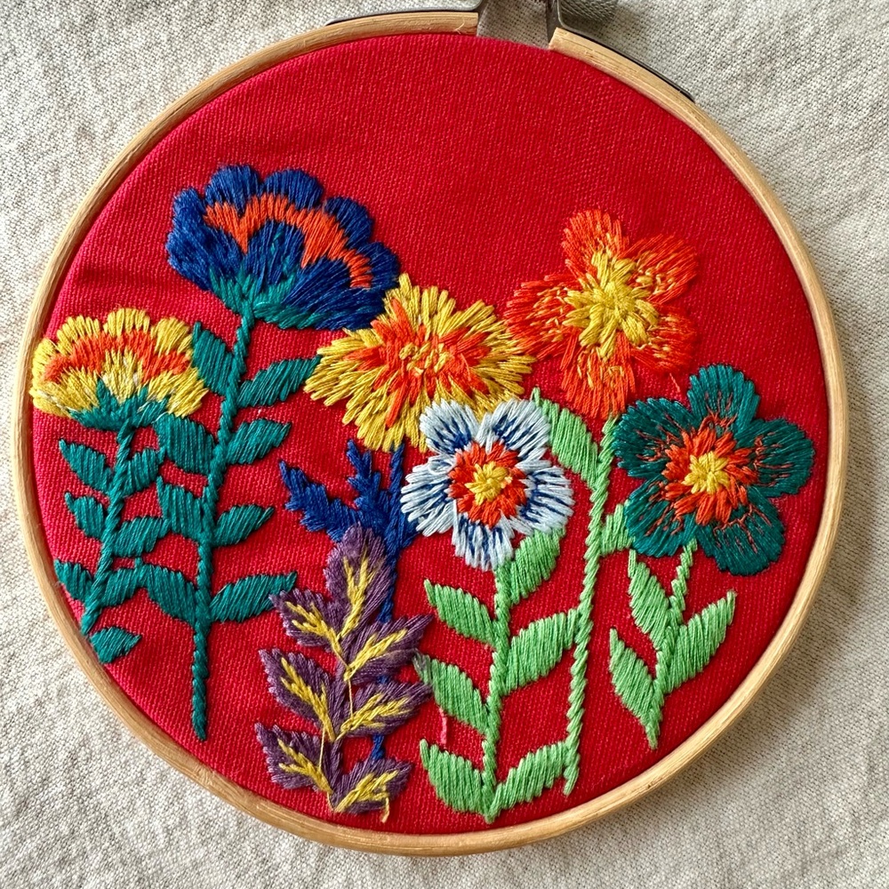 Vibrant Floral Embroidery Art on Red Canvas